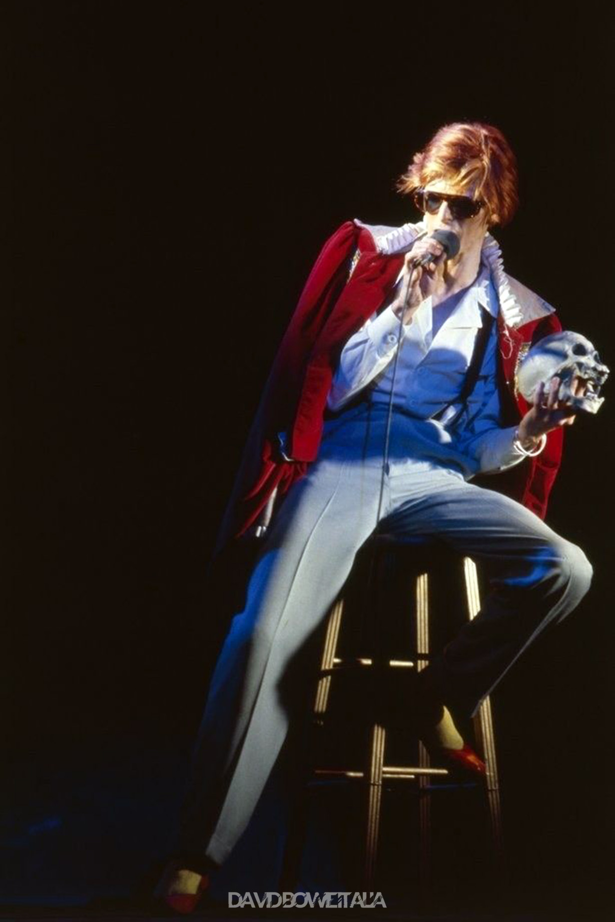 Diamond Dogs: ululati dal futuro 35 Bowie sul palco durante il Diamond Dogs Tour del 1974, con il teschio in mano e il costume rosso che evocano le atmosfere teatrali del personaggio Halloween Jack