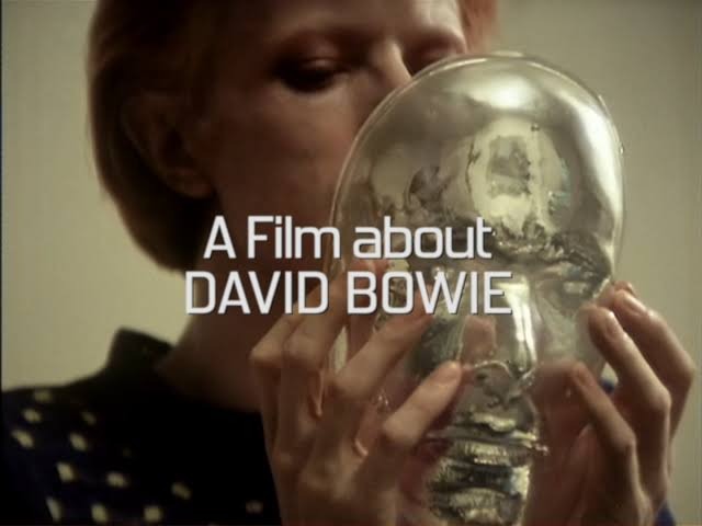 Diamond Dogs: ululati dal futuro 89 David Bowie guarda la maschera trasparente del proprio viso nei titoli di testa di Cracked Actor, con la scritta A Film about David Bowie
