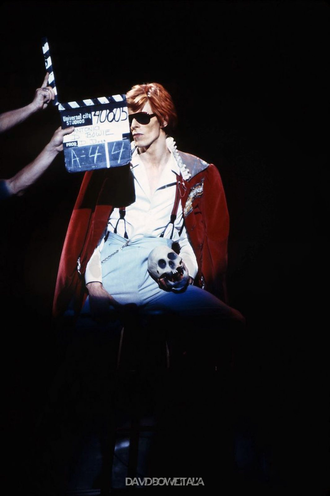 Diamond Dogs: ululati dal futuro 74 David Bowie con occhiali scuri e mantello davanti a un ciak durante Cracked Actor, Diamond Dogs Tour 1974